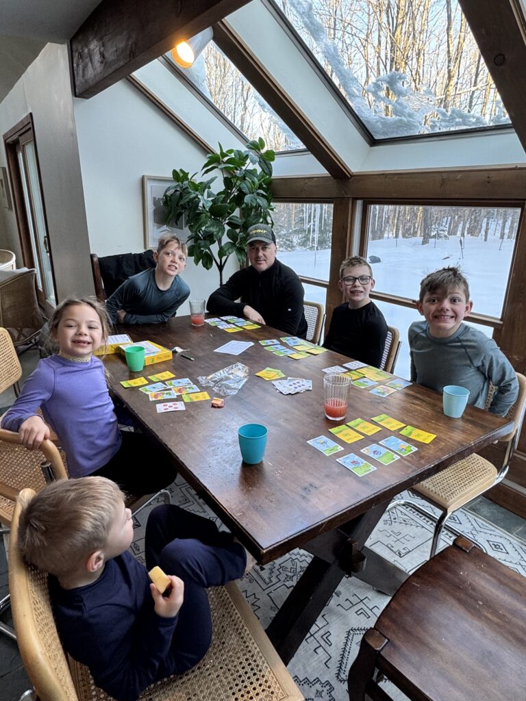 imgae of family playing cards in house with snowy background