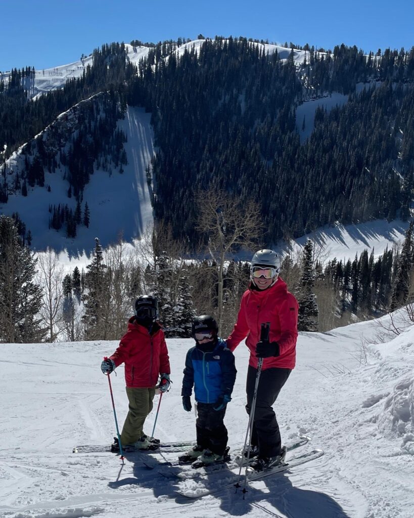 family with mountain backdrop on park city ski trip