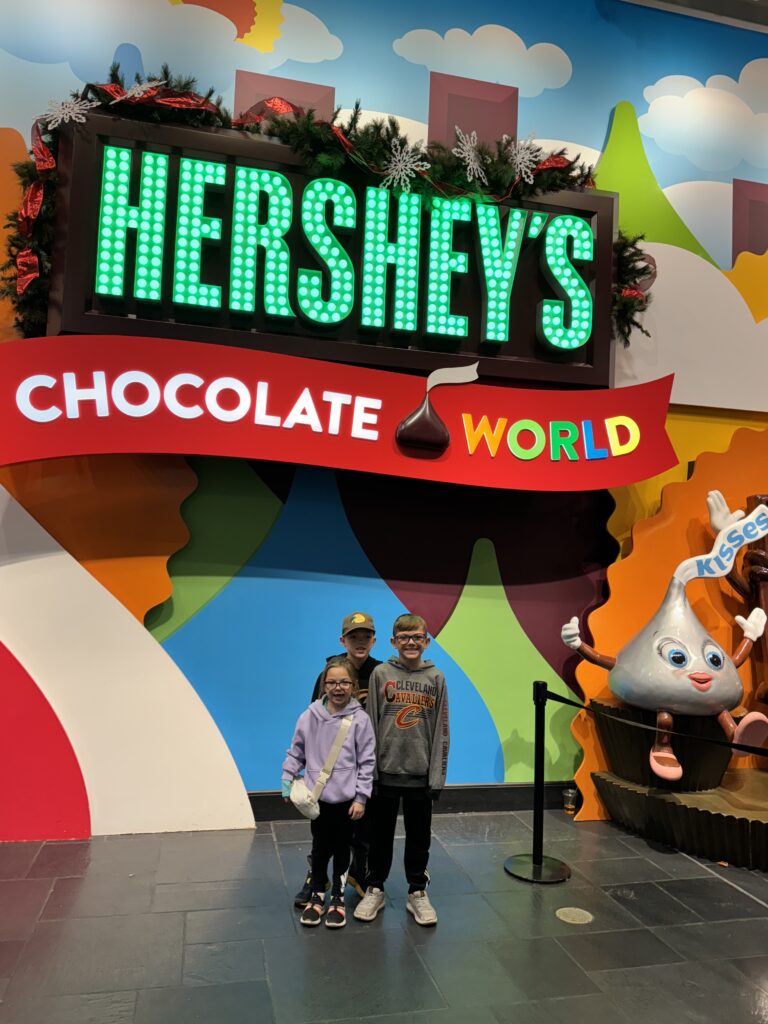 kids standing in front of hershey chocolate world sign