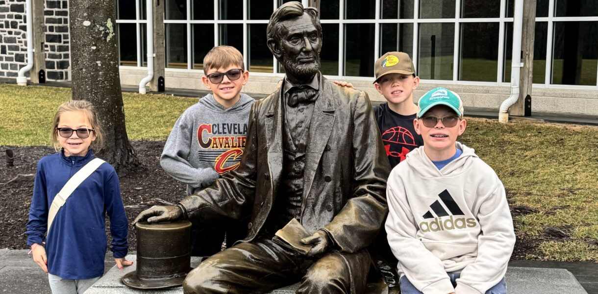 kids next to statue of abraham lincoln in front of gettysburg museum