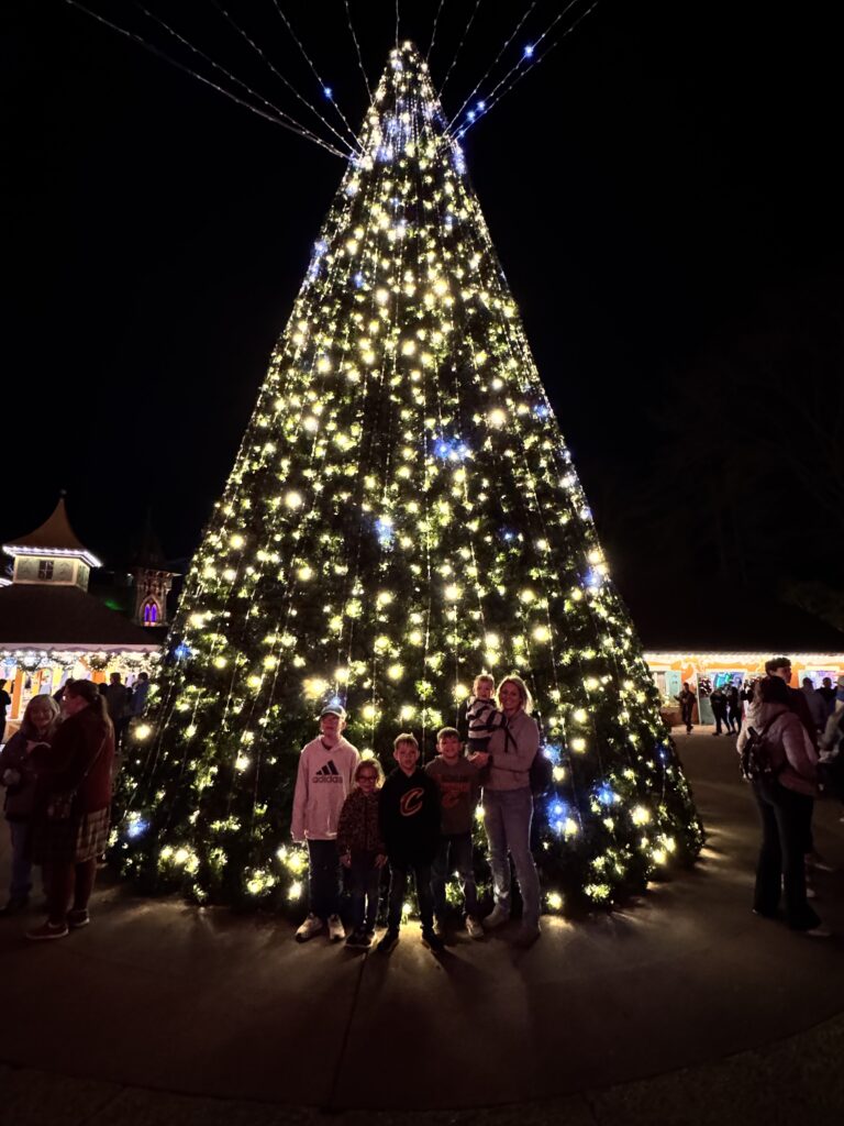 family in front of christmas tree at busch gardens christmas town williamsburg