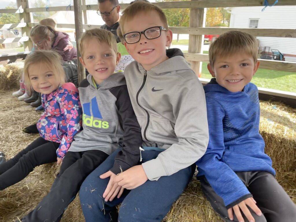 four kids on tractor ride at luther farms