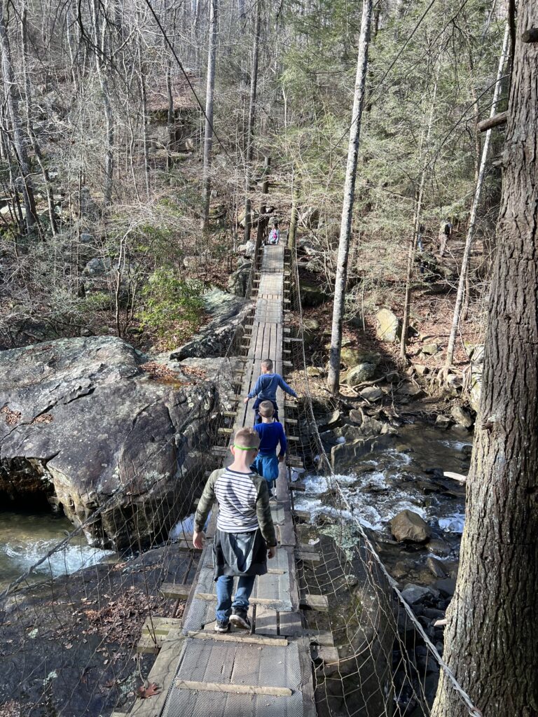 walking across bridge on rainbow falls hike