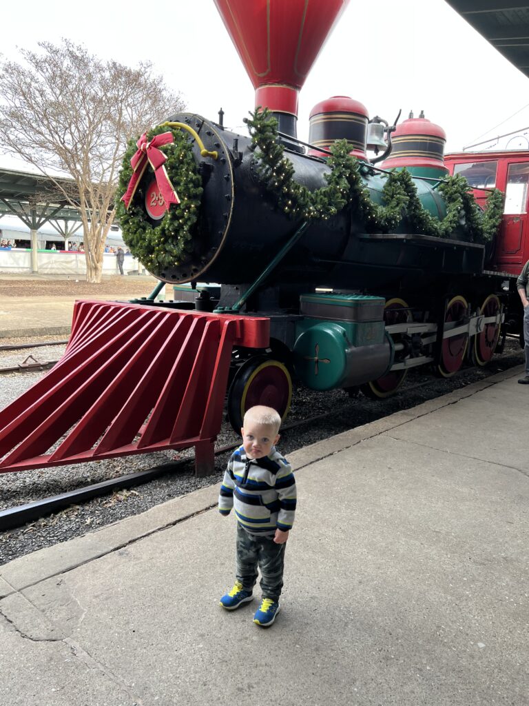 cute little boy in front of train at the landing chattanooga