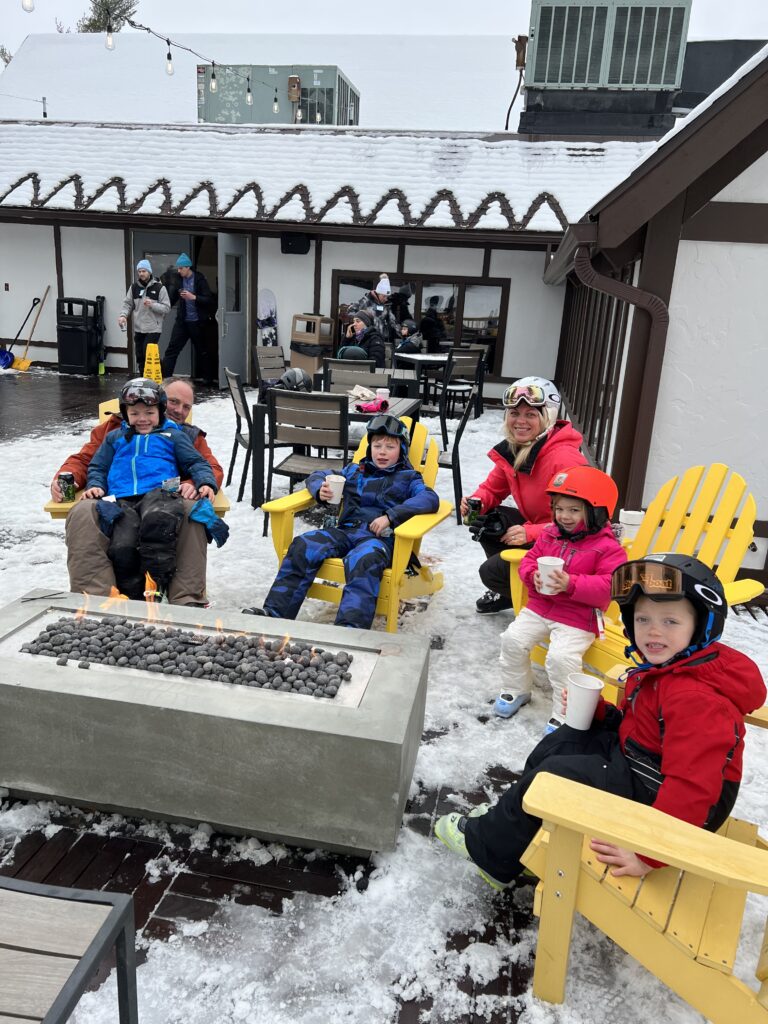family around a fire pit at peek n peak resort new york