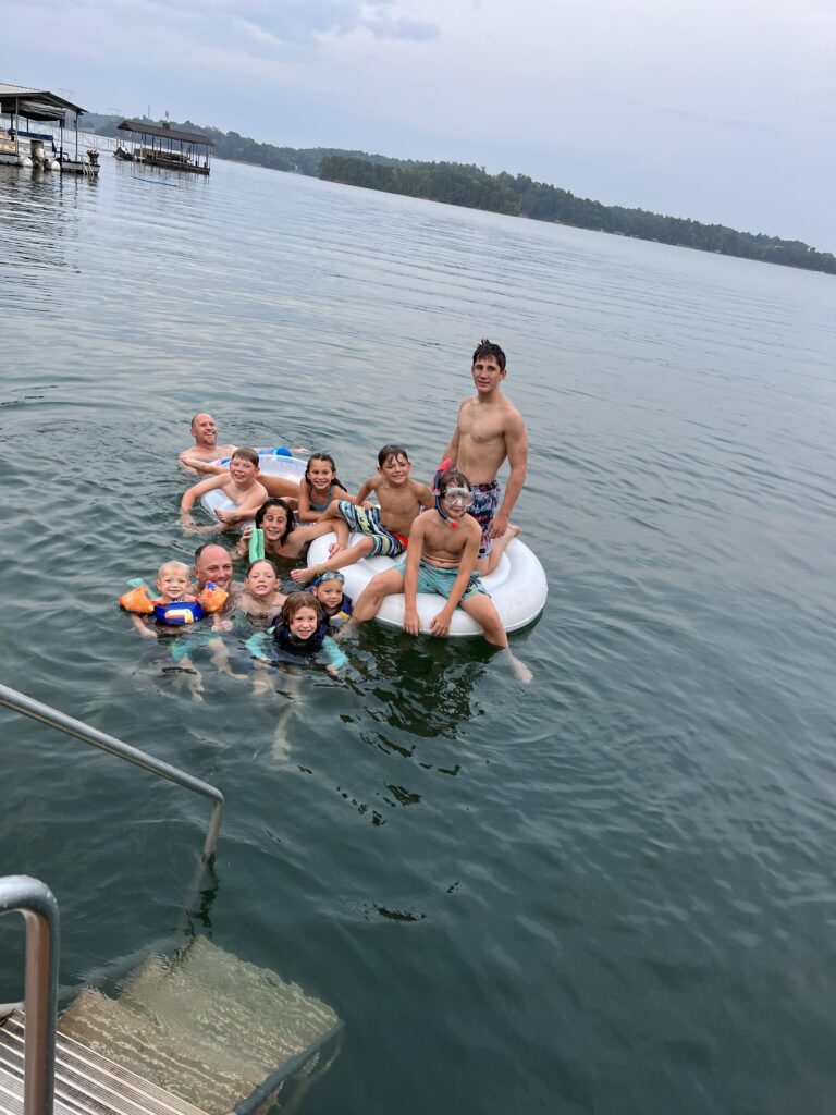 family having fun in water in lake keowee with kids vacation