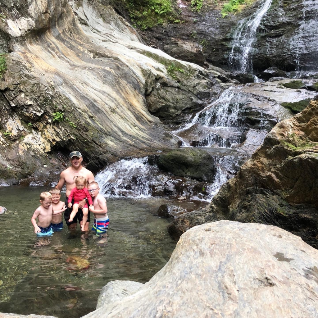 family in moss glenn falls in stowe vermont during summer 