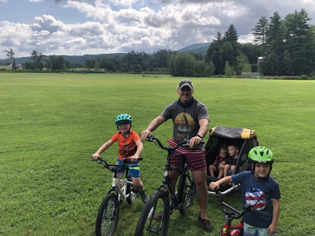 family riding bikes on stowe recreation path in stowe vermont during summer