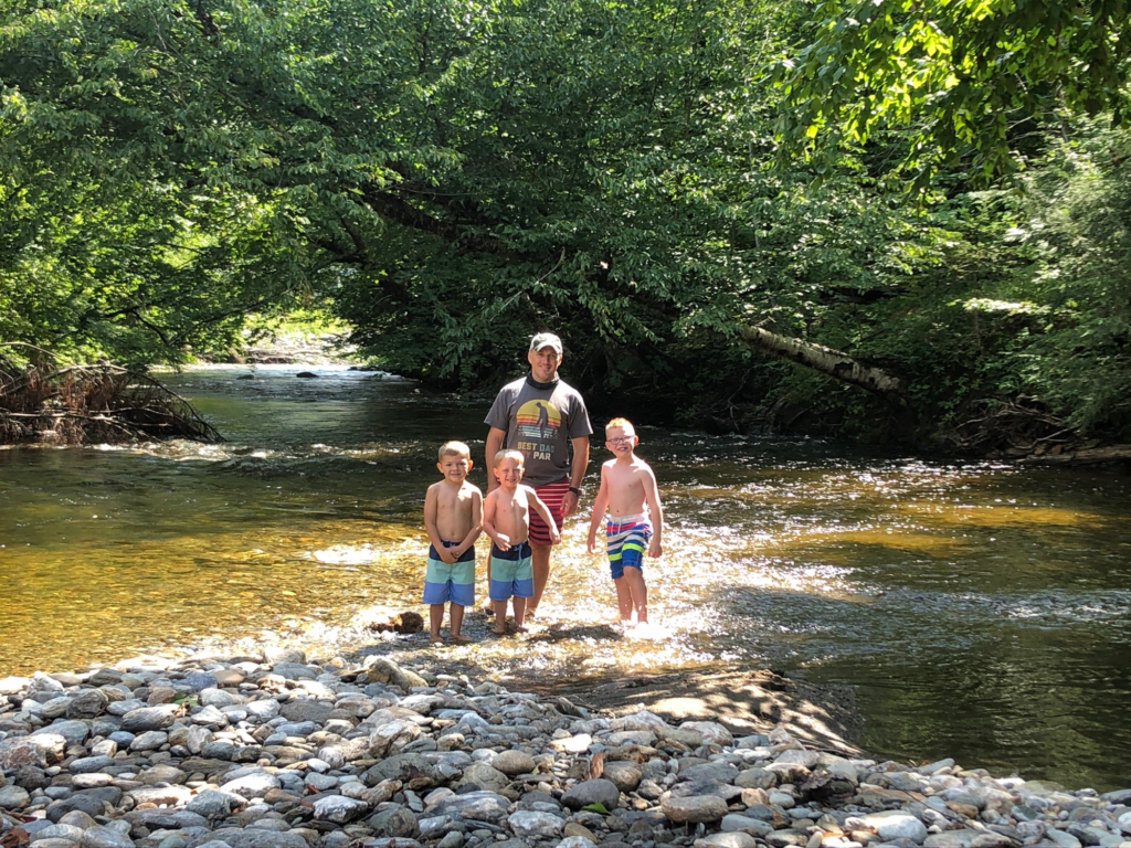 family in creek on stowe recreation path in Stowe Vermont during summer