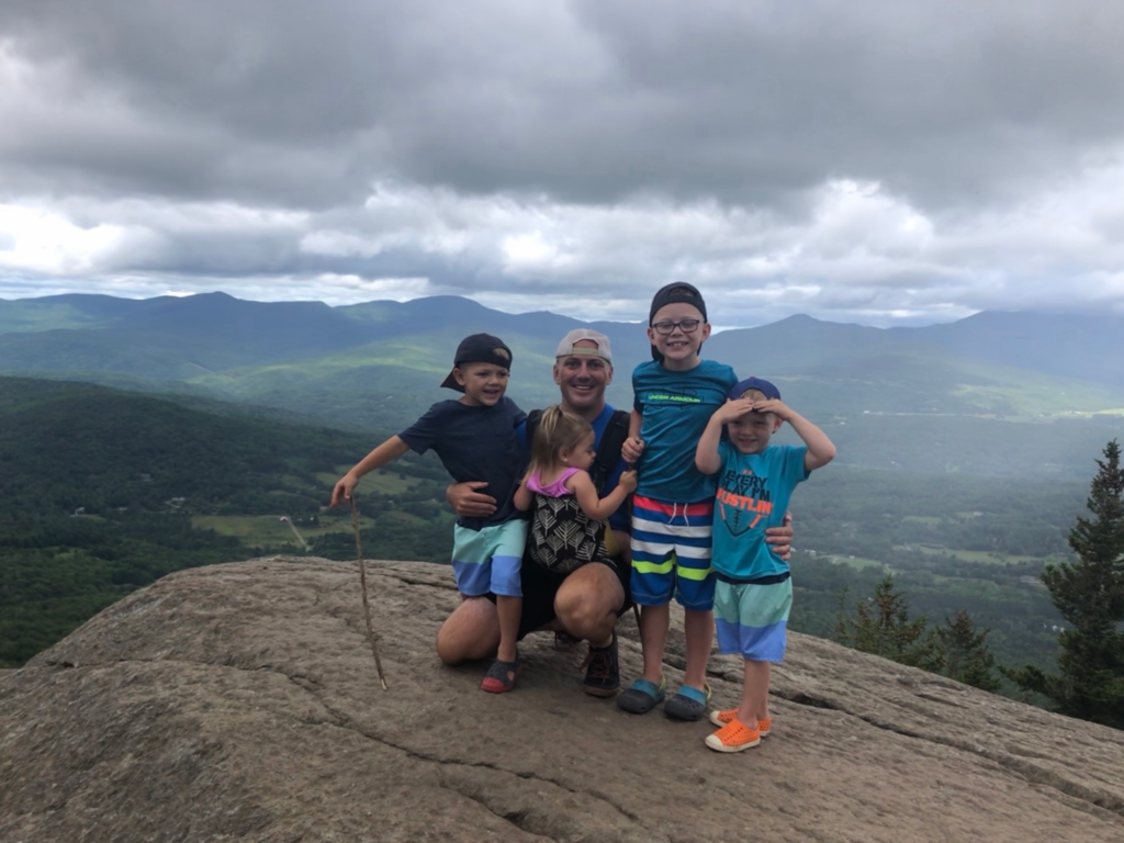 family at top of pinnacle trail in stowe vermont during summer 