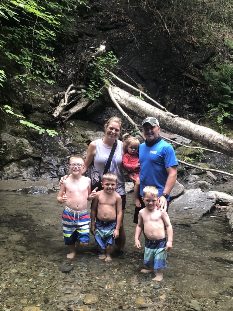 family at moss glenn falls in stowe vermont during summer 