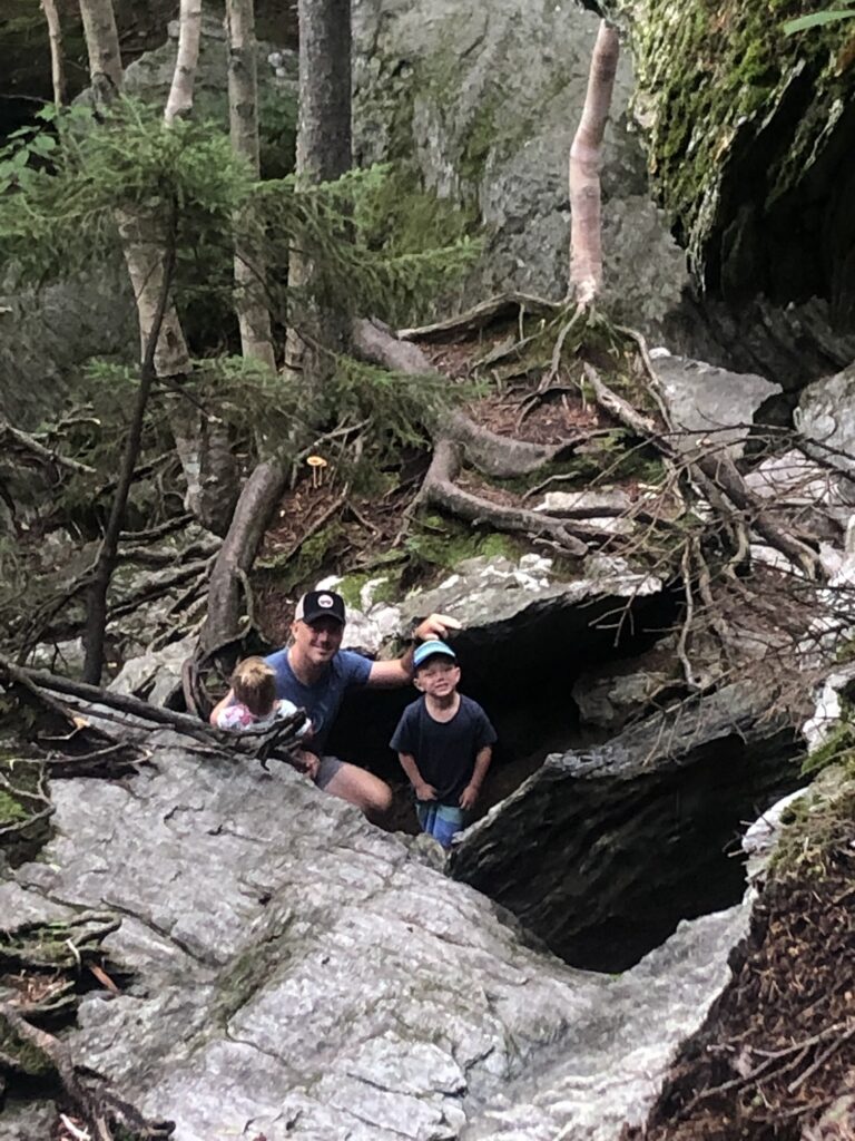 family in rocks at base of sterling pond in stowe vermont during summer