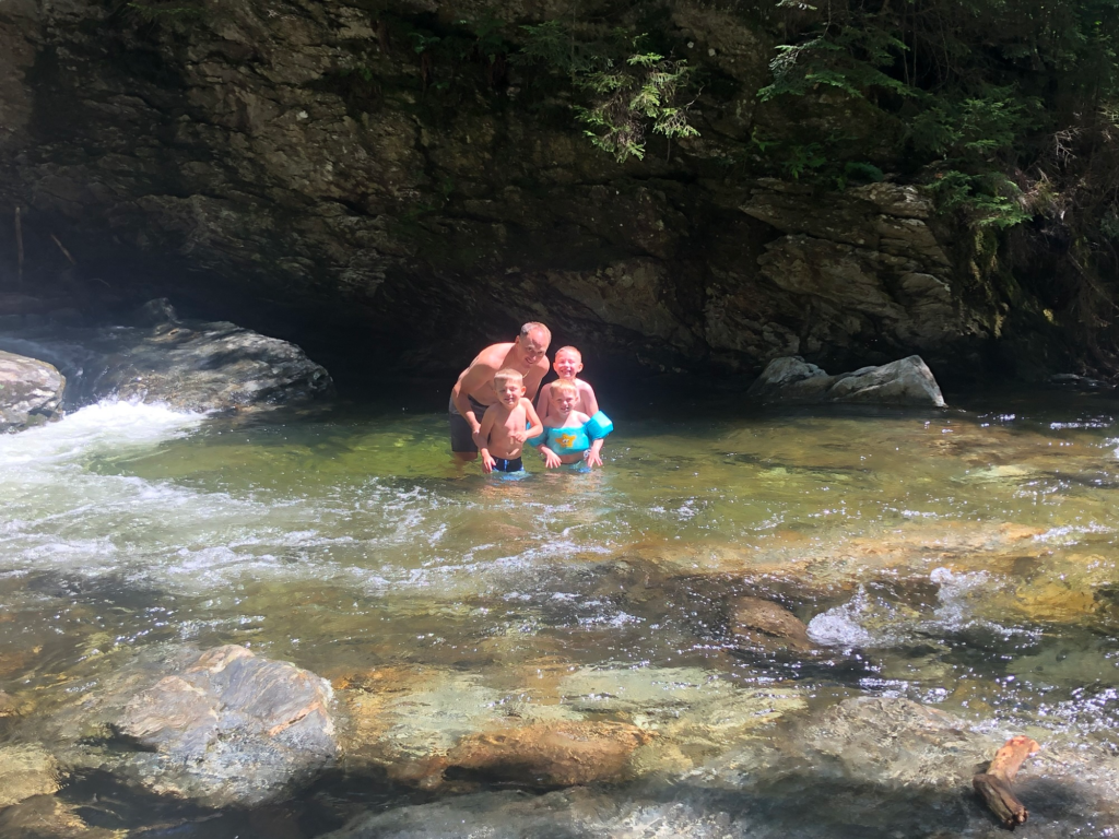 family in Bingham falls creek area in stowe vermont during summer 