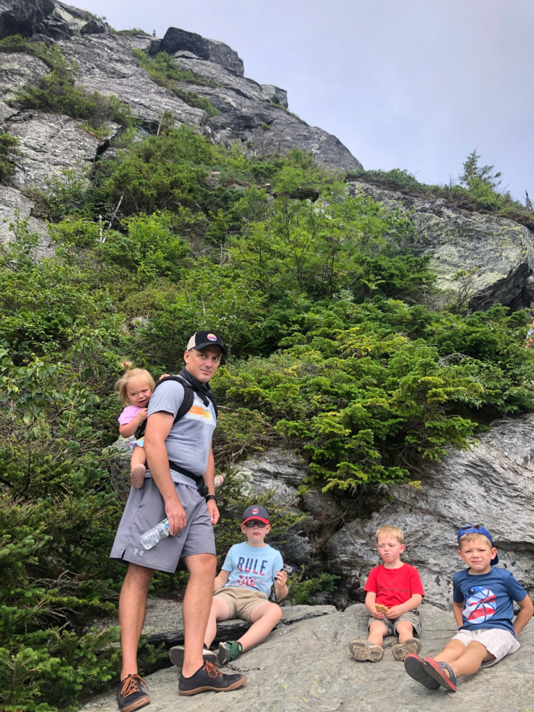 family climbing mount mansfield stowe vermont during summer