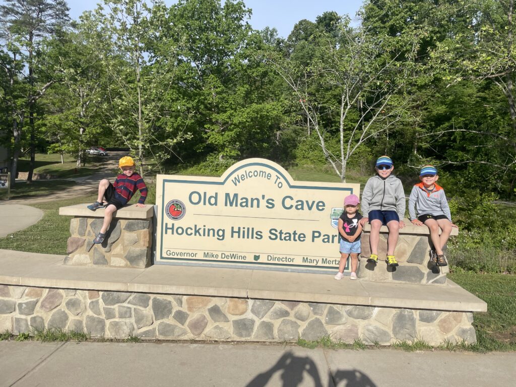 children in front of old man's cave sign hocking hills ohio